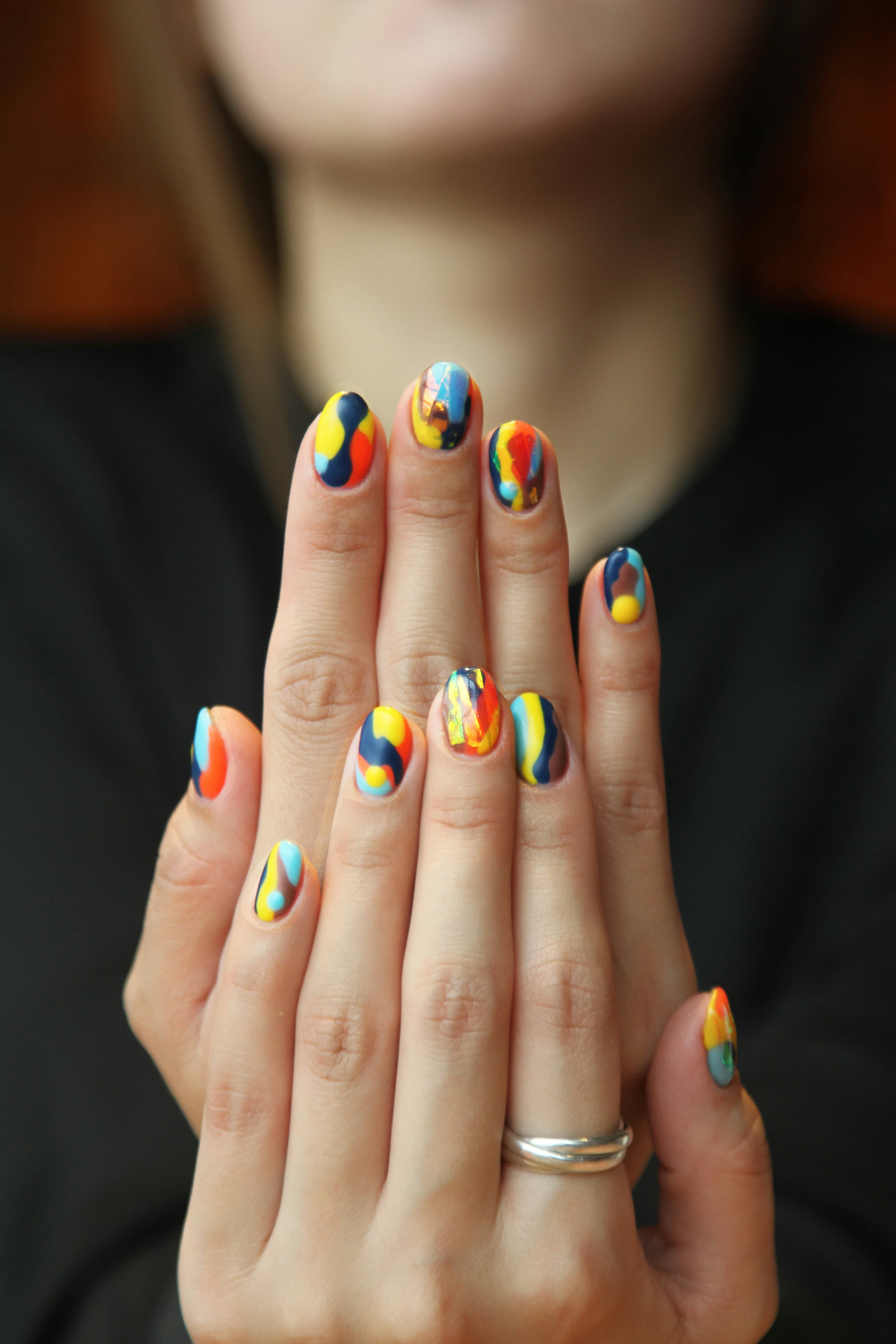 Hand with a multicolor abstract nail art set