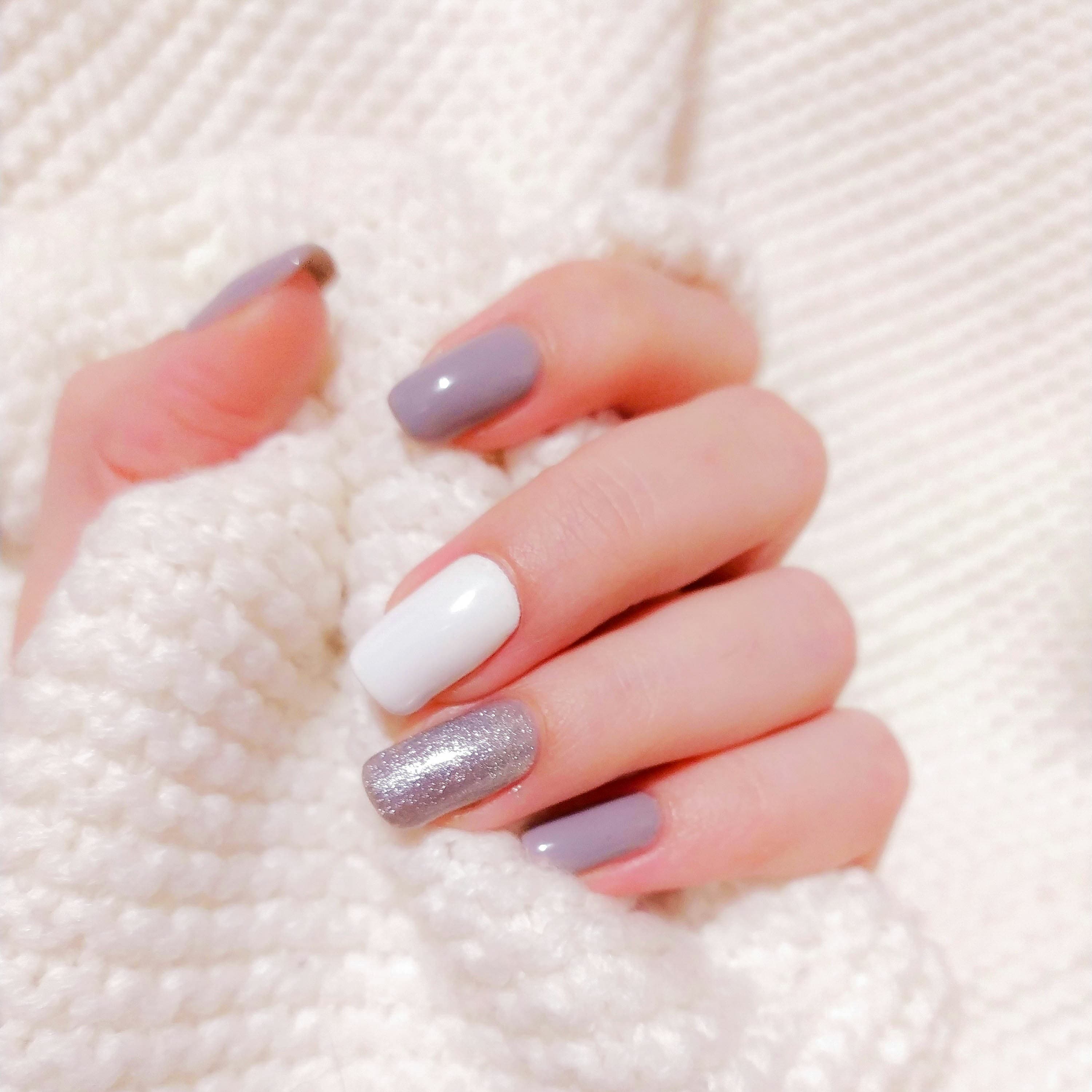 Mauve and glitter polish held against knitwear