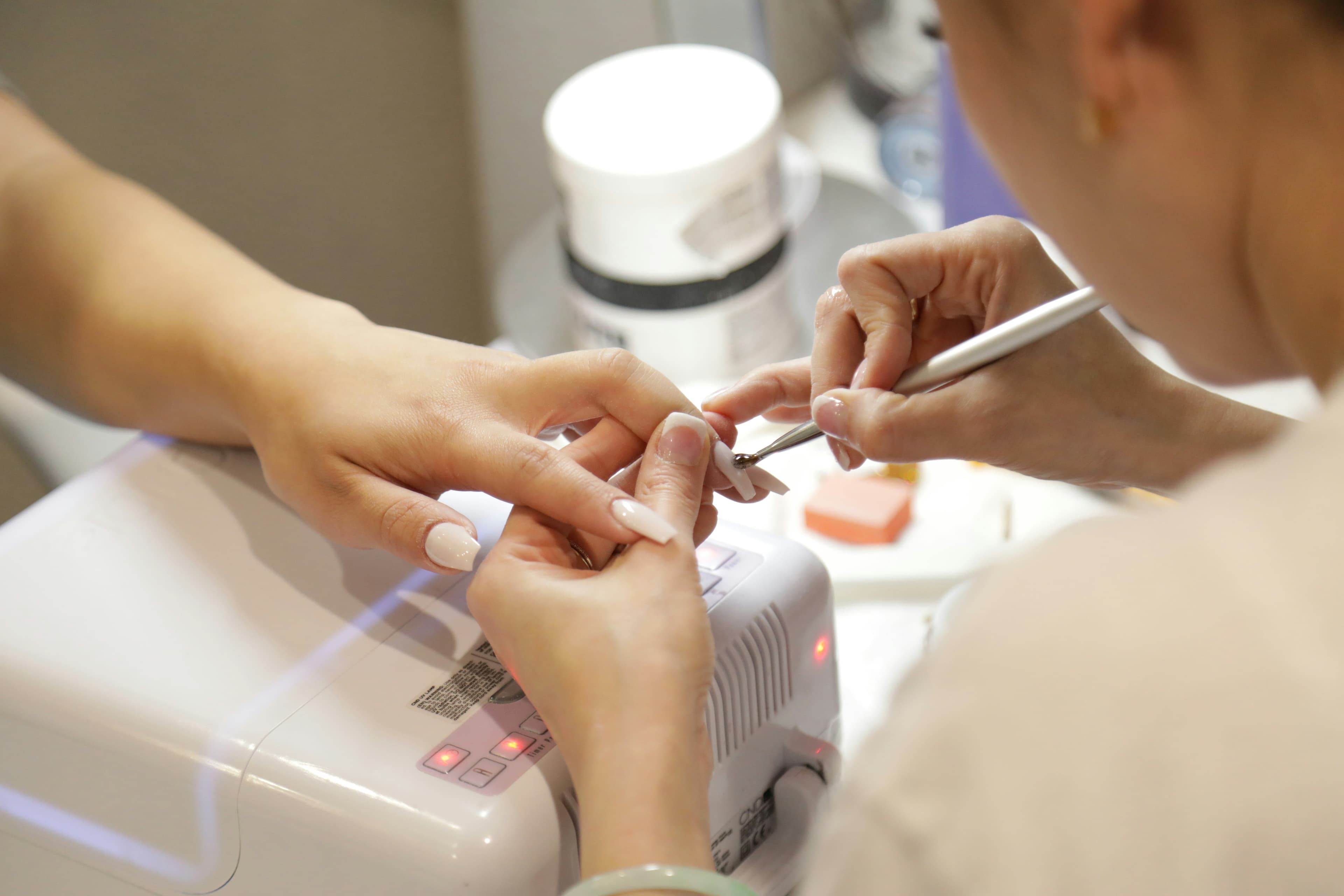 A client having her nails done at a salon station